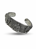Silver bracelet with intricate designs on a white background